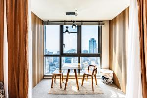釜山premium ocean view in HAEHUNDAE BONA TRAVEL的窗户前带桌椅的用餐室