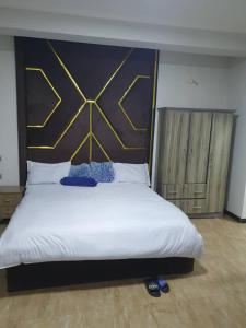 a bedroom with a large bed with a large headboard at Revo guest house in Addis Ababa