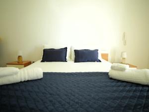 ein Schlafzimmer mit einem großen Bett mit blauer Bettwäsche und Kissen in der Unterkunft Casa Manuela in Lecce