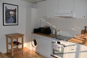 een keuken met een wasmachine en een wasmachine bij Charmante maison avec jardin et air conditionné au coeur d'un village historique ! in Verneuil-en-Bourbonnais