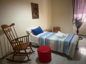 a bedroom with a bed and a rocking chair at Casa Alleria in Battipaglia