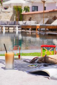 a drink on a table next to a swimming pool at Alaçatı Limonaia Hotel in Alaçatı
