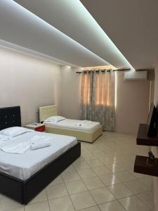 een kamer met 2 bedden en een tv. bij Bar Hotel Orgito in Lushnjë