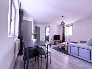 ein Wohnzimmer mit Tisch und Couch in der Unterkunft Appartement Cosy Auxerre centre ville Arrivée autonome in Auxerre
