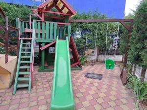 a playground with a green slide and a ladder at Casa Family in Jupiter
