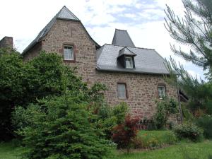 une ancienne maison en briques avec un toit en gambrel dans l'établissement Chambres d'Hôtes La Roumec, à Escandolières