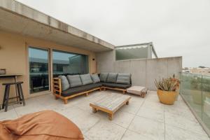 a patio with a couch and a table at Beach & Sun Apartment by Vacationy in Bomfim