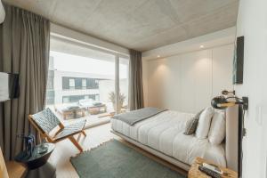 a bedroom with a bed and a large window at Beach & Sun Apartment by Vacationy in Bomfim