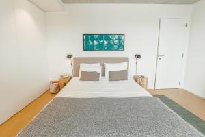 a bedroom with a large white bed with two pillows at Beach & Sun Apartment by Vacationy in Bomfim