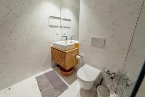 a white bathroom with a toilet and a sink at Beach & Sun Apartment by Vacationy in Bomfim +16 photos