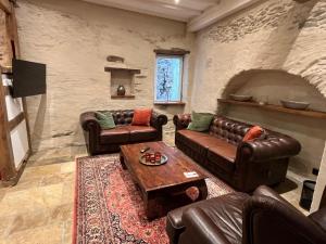 a living room with leather couches and a table at Scheune Am alten Posthof Lieser in Lieser