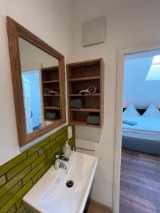 a bathroom with a sink and a mirror and a bed at Scheune Am alten Posthof Lieser in Lieser +26 photos