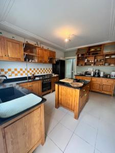 a large kitchen with wooden cabinets and an island at Appartement cosy et chaleureux in Hammam Sousse