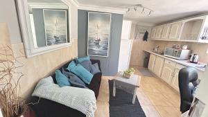 a living room with a couch and a kitchen at Artzys private Flatlet 1km to Olivedale Clinic in Northriding