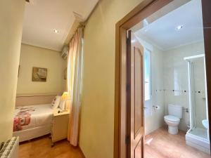 ein kleines Badezimmer mit einem Bett und einer Toilette in der Unterkunft Luz Madrid Rooms in Madrid + 39 Fotos