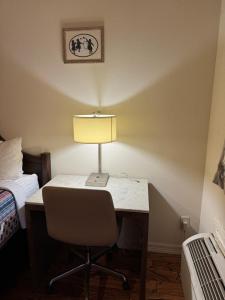 a desk with a lamp and a chair in a room at Jackson Inn in El Campo