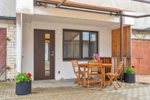 a wooden table and chairs on a patio at 60 Vėtrungių in Neringa