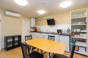 a kitchen with a wooden table and a dining room at 60 Vėtrungių in Neringa