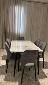a dining room table with chairs and a white table at شقة مميزه بتصميم عصري in Baljurashi