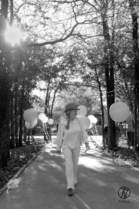 a woman is walking down a path with balloons at The Skittles Unit in Austin