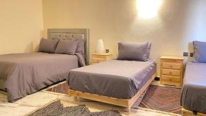 a bedroom with two beds and two night stands at Beach House Douira in Agadir +37 photos