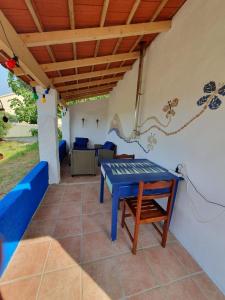 a patio with a blue table and a couch at Baranca Stima in Aldeia de Além