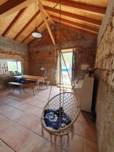 a room with a hammock in a room with a table at Baranca Stima in Aldeia de Além +10 photos