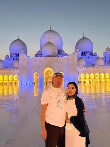 a man and a woman standing in front of a mosque at Luxe Hotel in Kazarman