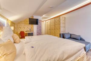 a hotel room with a large bed and a couch at Hotel Hirschenstein in Achslach