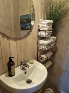 a bathroom with a sink and a mirror and towels at Lila Rummet in Kyrkesund