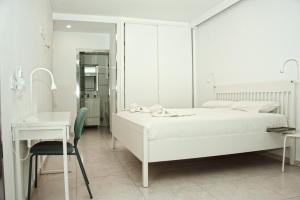 a white bedroom with a bed and a desk at Happy Space Apartment in Los Cristianos +21 photos