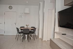 a dining room with a table and chairs and a television at Happy Space Apartment in Los Cristianos