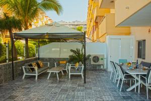 a patio with a table and chairs and an umbrella at Happy Space Apartment in Los Cristianos
