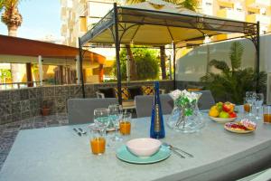 a table with a bowl of fruit and glasses of orange juice at Happy Space Apartment in Los Cristianos
