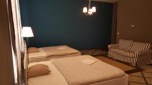 Habitación con 2 camas, silla y lámpara de araña. en Premier Inn Apartments en Budapest