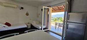 a room with two beds and a refrigerator and a balcony at T2 Résidence Dolce & Vita B3 avec piscine in Propriano +23 photos