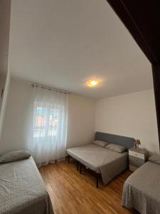 a bedroom with two beds and a window at Alloggio peonia in Riva del Garda