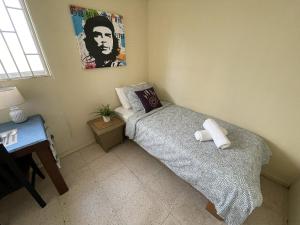 a small bedroom with a bed and a desk at Simple Studio at Studenthouse Casa Caia in Willemstad