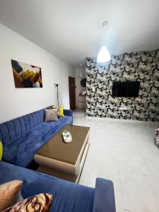 Cabonegro appartement في كابو نيغرو: غرفة معيشة مع أريكة زرقاء وتلفزيون +11 صورة