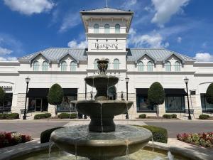a fountain in front of a building with a clock tower at Private Room in Ballantyne in Charlotte