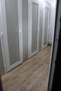 an empty room with four doors and a wooden floor at Glamping Costinești in Costinesti