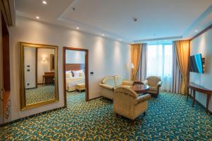 トゥズラにあるHotel Mellainの大きな鏡とベッドルームが備わるホテルルームです。