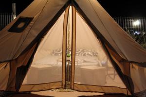 a tent with a bed in it at night at Glamping Costinești in Costinesti