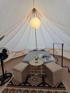 a room with a bed and a table in a tent at Glamping Costinești in Costinesti
