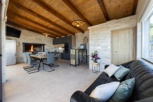 a living room with a leather couch and a kitchen at Villa Bijaći in Kastel Novi