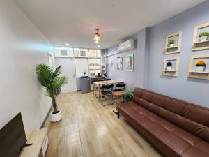 ein Wohnzimmer mit Sofa und Tisch in der Unterkunft Cozy Private Family Apartment in Bangkok CBD Silom-Sathorn - 240m to BTS Saint Louis in Yan Nawa