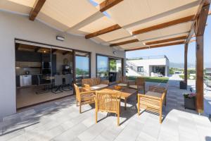 an outdoor patio with a table and chairs and a kitchen at Villa Bijaći in Kastel Novi