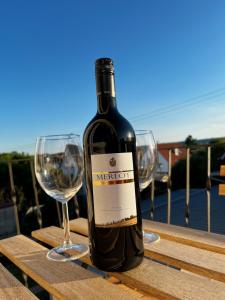 a bottle of wine sitting on a table with two wine glasses at Deluxe Apartment in Jettingen-Scheppach +4 photos