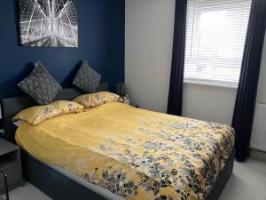 een slaapkamer met een bed met een geel dekbed bij The White House in High Ackworth