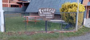 Una valla con un cartel con una mesa de picnic. en Freecis, en Esquel